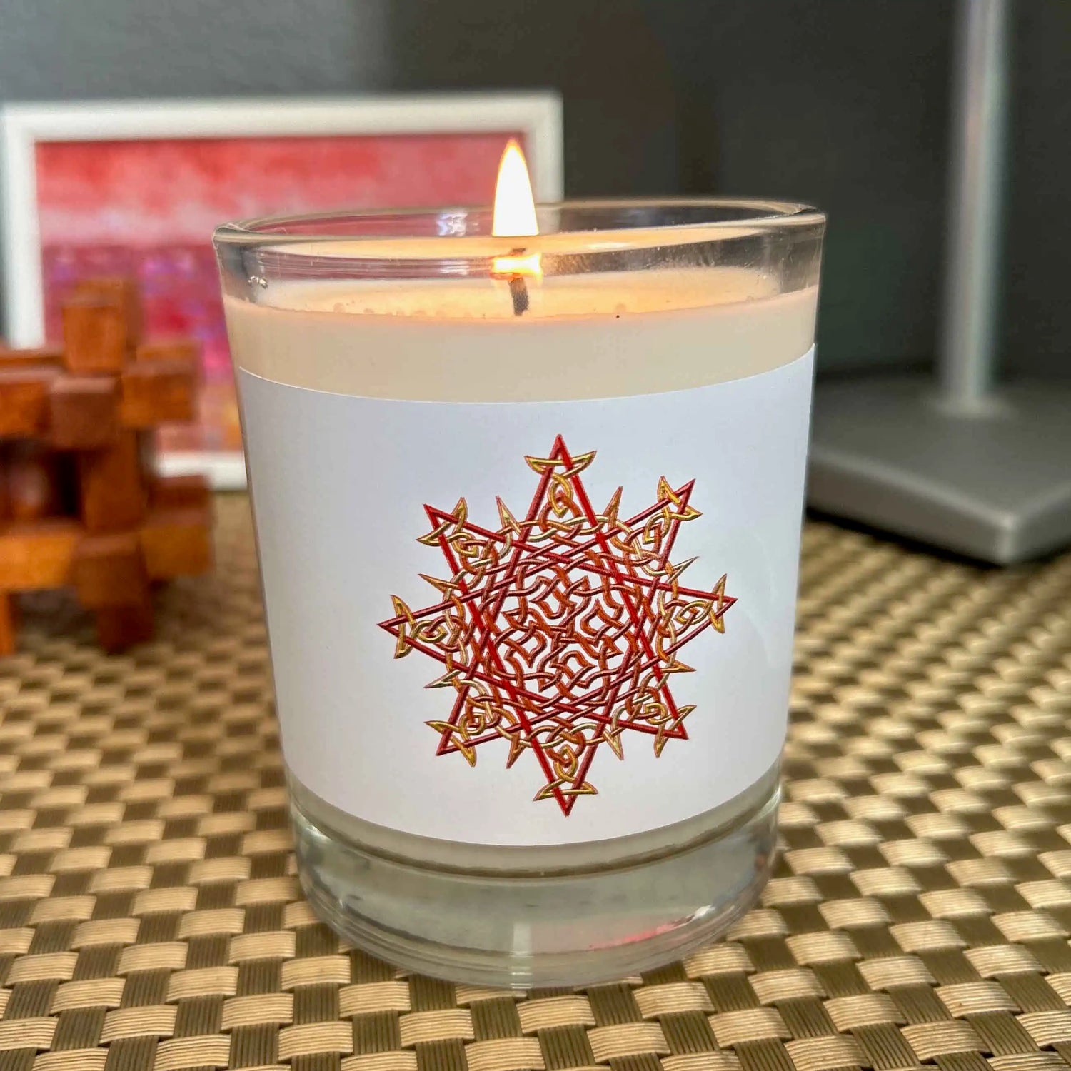 Xigfireon Morning Star Fire Celtic knot scented candle with Fire Colour label design on wooden surface with warm lighting.
