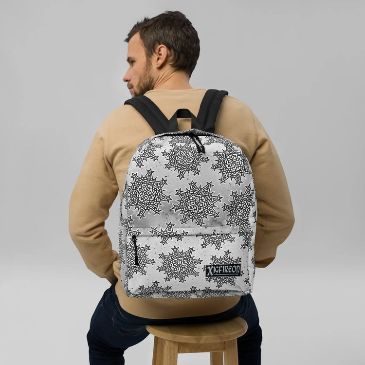 A student wearing a Xigfireon graphic backpack featuring the Black & White Solid Cosmos Inverted iteration of the `Morning Star Fire` Celtic knot pattern. The `Morning Star Fire` Celtic knot symbolizes the Sun.