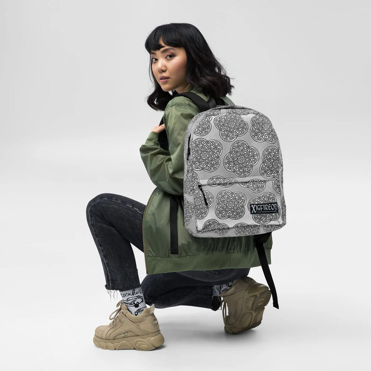 A student wearing a Xigfireon graphic backpack featuring the Black & White Solid Forest Inverted iteration of the `Reach Of The Spirit` Celtic knot pattern. The `Reach Of The Spirit` Celtic knot symbolizes Mother Earth.
