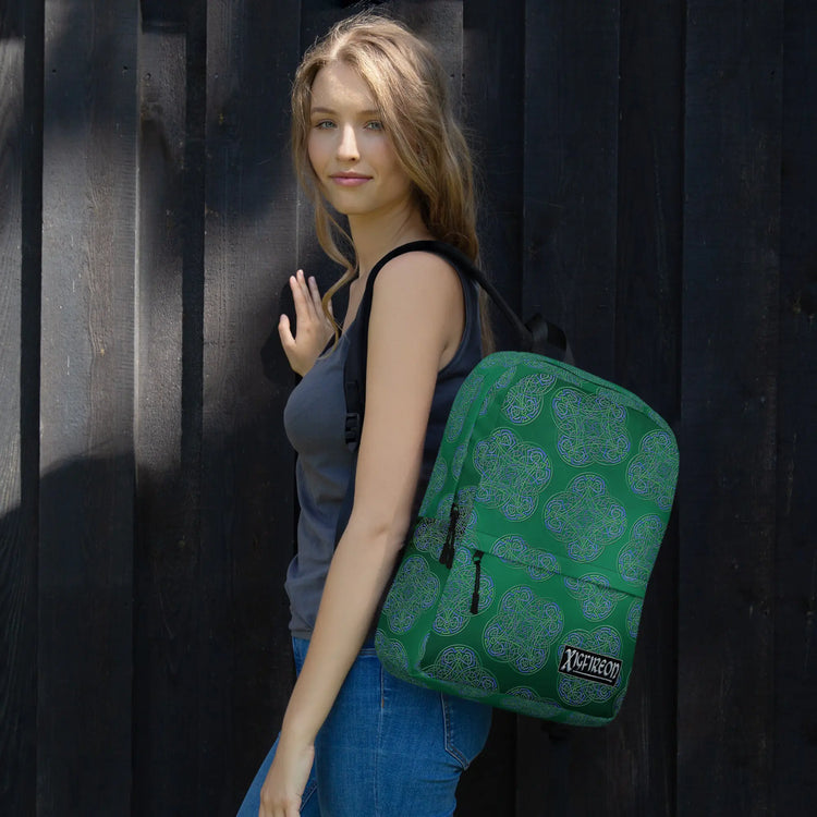 A student wearing a Xigfireon graphic backpack featuring the Living Colour Forest Inverted iteration of the `Reach Of The Spirit` Celtic knot pattern. The `Reach Of The Spirit` Celtic knot symbolizes Mother Earth.