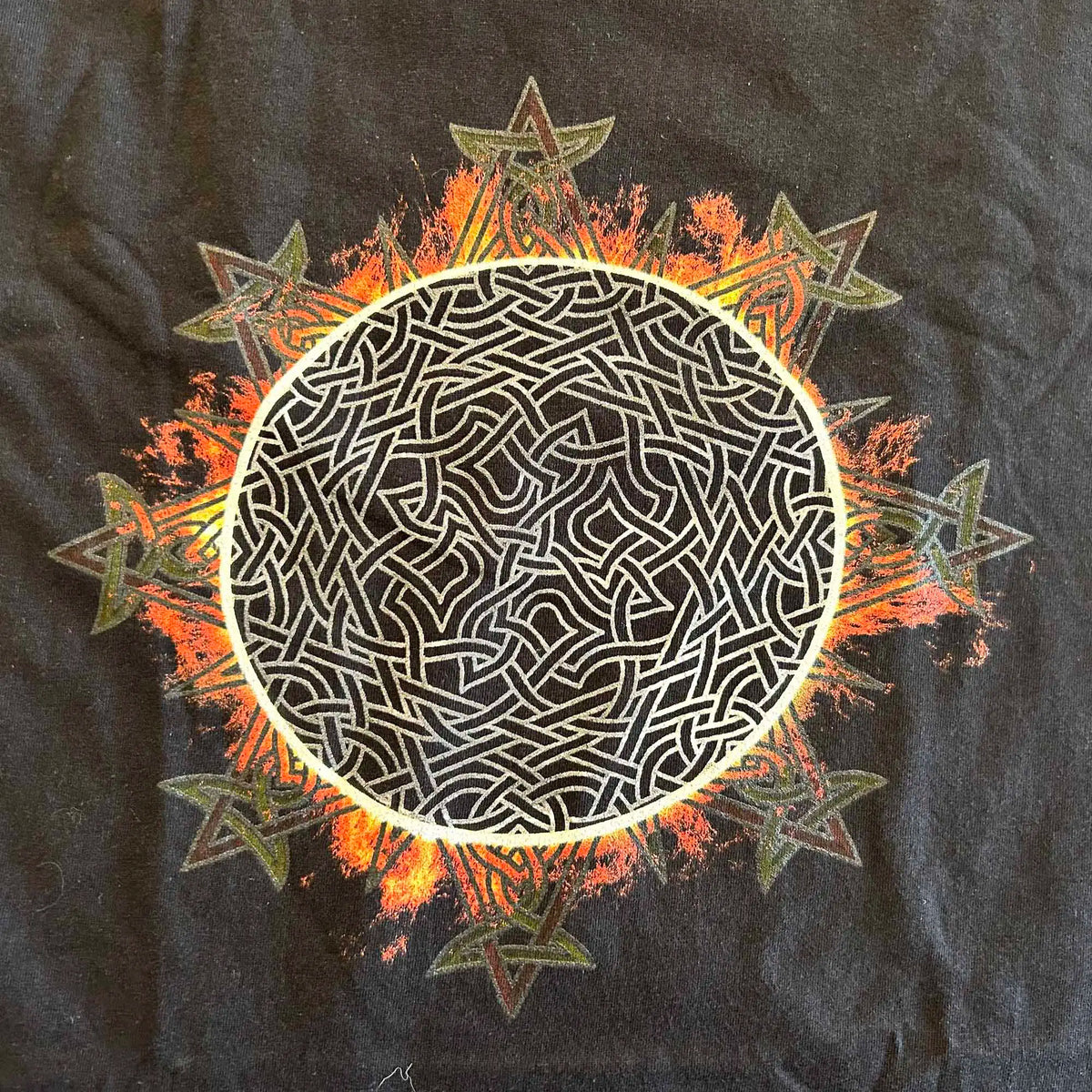 A close-up view of a classic black Xigfireon graphic tee featuring the Eclipsed iteration of the Morning Star Fire Celtic knot design, inspired by the Annular Solar Eclipse of 2023.