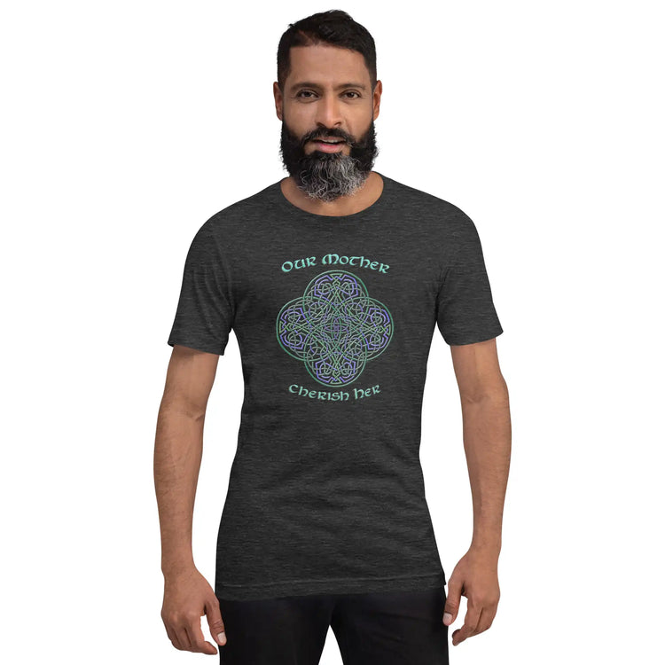 A young man wearing a dark grey heather graphic t-shirt featuring the Living Colour iteration of the `Reach Of The Spirit` Celtic knot design along with a message in a Celtic font: "Our Mother, Cherish Her".