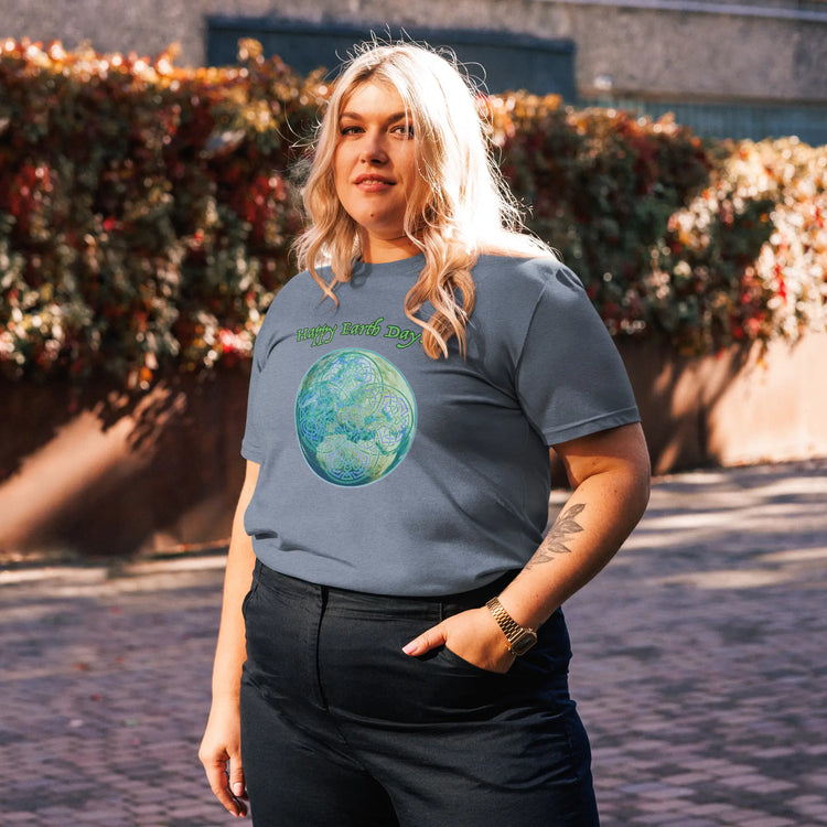 A young woman wearing a dark heather blue organic graphic t-shirt featuring the Sacred Planet iteration of the `Reach Of The Spirit` Celtic knot design under a message reading "Happy Earth Day".