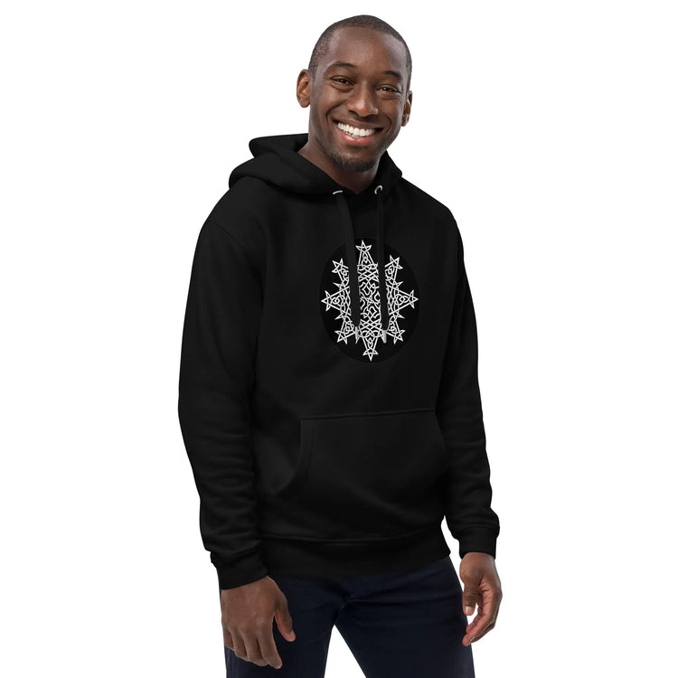 A young man wearing a black Xigfireon graphic eco hoodie featuring the Black & White Circle iteration of the `Morning Star Fire` Celtic knot design. The `Morning Star Fire` Celtic knot symbolizes the Sun.