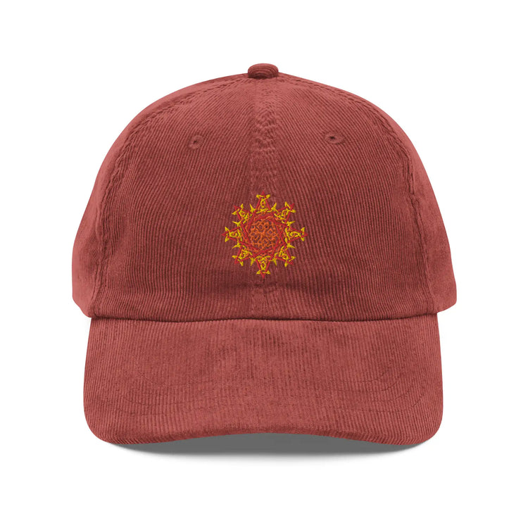 The front side of a burgundy Xigfireon vintage corduroy cap embroidered with the Fire Colour iteration of the `Morning Star Fire` Celtic knot design.