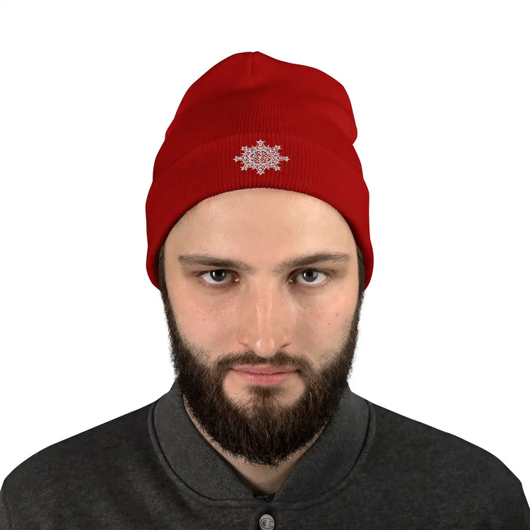 A young man wearing a red Xigfireon knit beanie embroidered with the White iteration of the `Morning Star Fire` Celtic knot design.