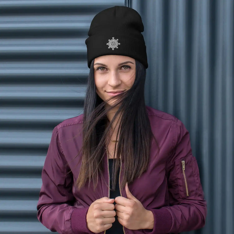 A young woman wearing a black Xigfireon knit beanie embroidered with the White iteration of the `Morning Star Fire` Celtic knot design.