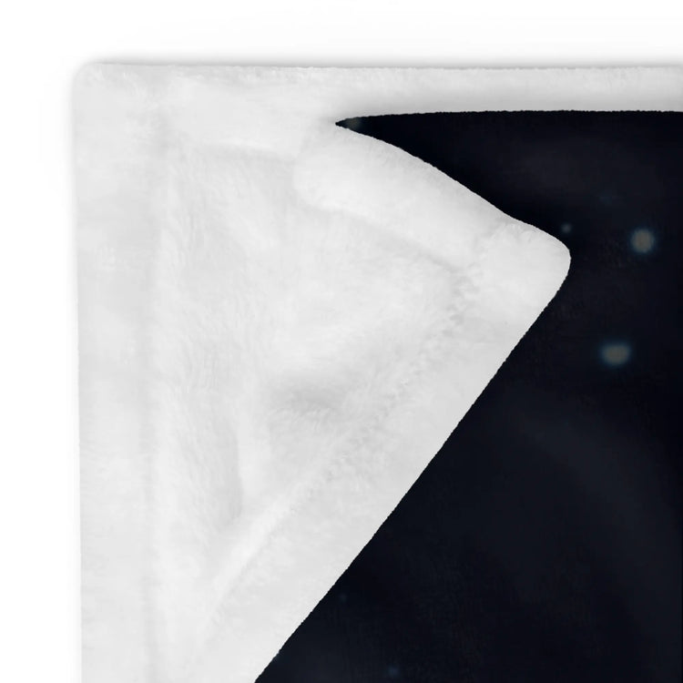 A close-up of the corner of a 60 inch by 80 inch Xigfireon throw blanket featuring the Eclipsed iteration of the `Morning Star Fire` Celtic knot design, showing its soft, silky fibers.