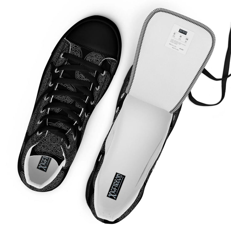 A view from above of a pair of Xigfireon black soled canvas high tops featuring the Greyscale iteration of the `Reach Of The Spirit` Celtic knot pattern. The tongue on the right shoe is opened up to better reveal the inside of the shoe.