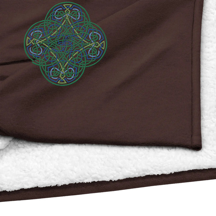 A close-up view of a fireside brown Xigfireon sherpa blanket embroidered with the Living Colour iteration of the `Reach Of The Spirit` Celtic knot design.