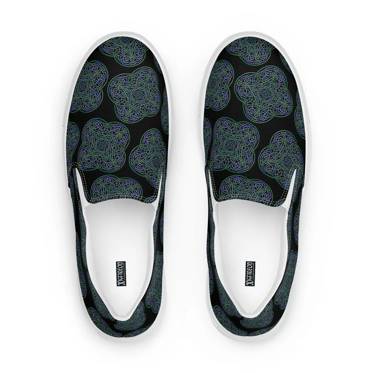 A view from above of a pair of Xigfireon canvas slip-on shoes featuring the Living Colour on Black iteration of the `Reach Of The Spirit` Celtic knot pattern. The Xigfireon logo is visible inside each shoe.
