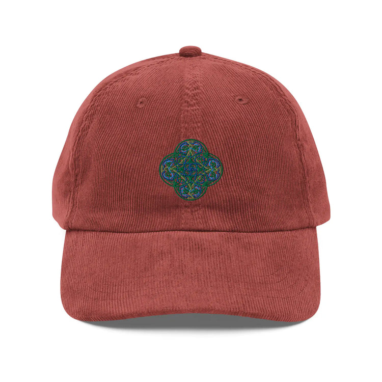 The front side of a burgundy Xigfireon vintage corduroy cap embroidered with the Living Colour iteration of the `Reach Of The Spirit` Celtic knot design.
