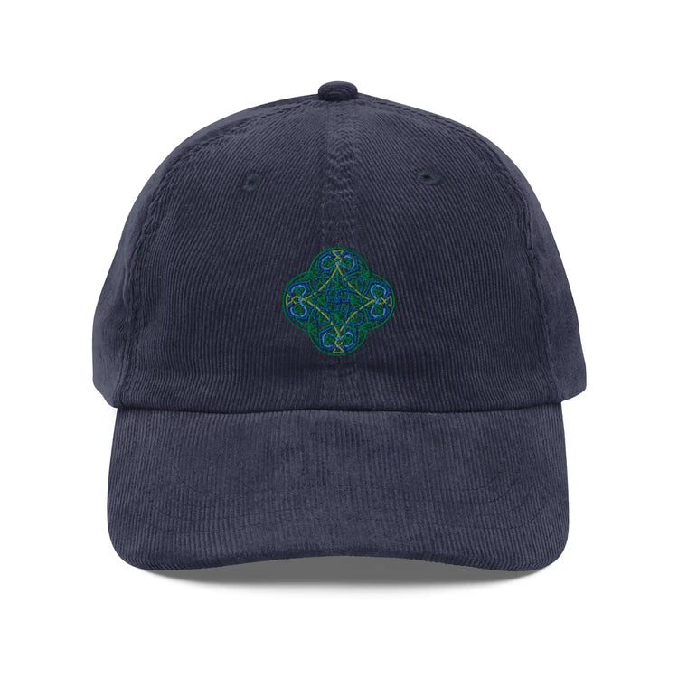 The front side of a navy blue Xigfireon vintage corduroy cap embroidered with the Living Colour iteration of the `Reach Of The Spirit` Celtic knot design.