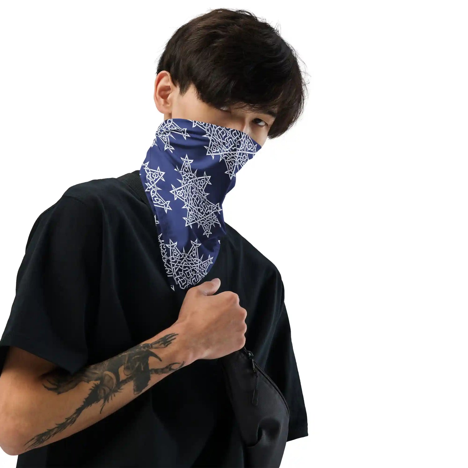 A young man wearing a Xigfireon bandana as a face covering. The bandana is adorned with the Navy Blue and White patterned series of the `Morning Star Fire` Celtic knot design.