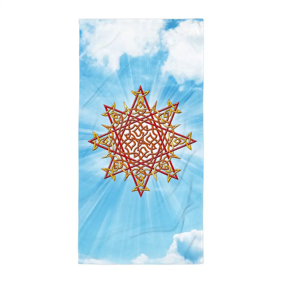 A Xigfireon beach towel featuring the Fire Colour iteration of the `Morning Star Fire` Celtic knot shown radiating rays of sunlight in a cloud laden blue sky.