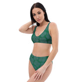 A young woman wearing a Xigfireon graphic bikini featuring the Living Colour Forest patterned series of the Reach Of The Spirit Celtic knot design.