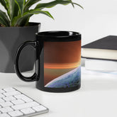 An office desk displaying an 11oz Xigfireon black glossy graphic mug featuring the Derivation II Celtic knots merger design.
