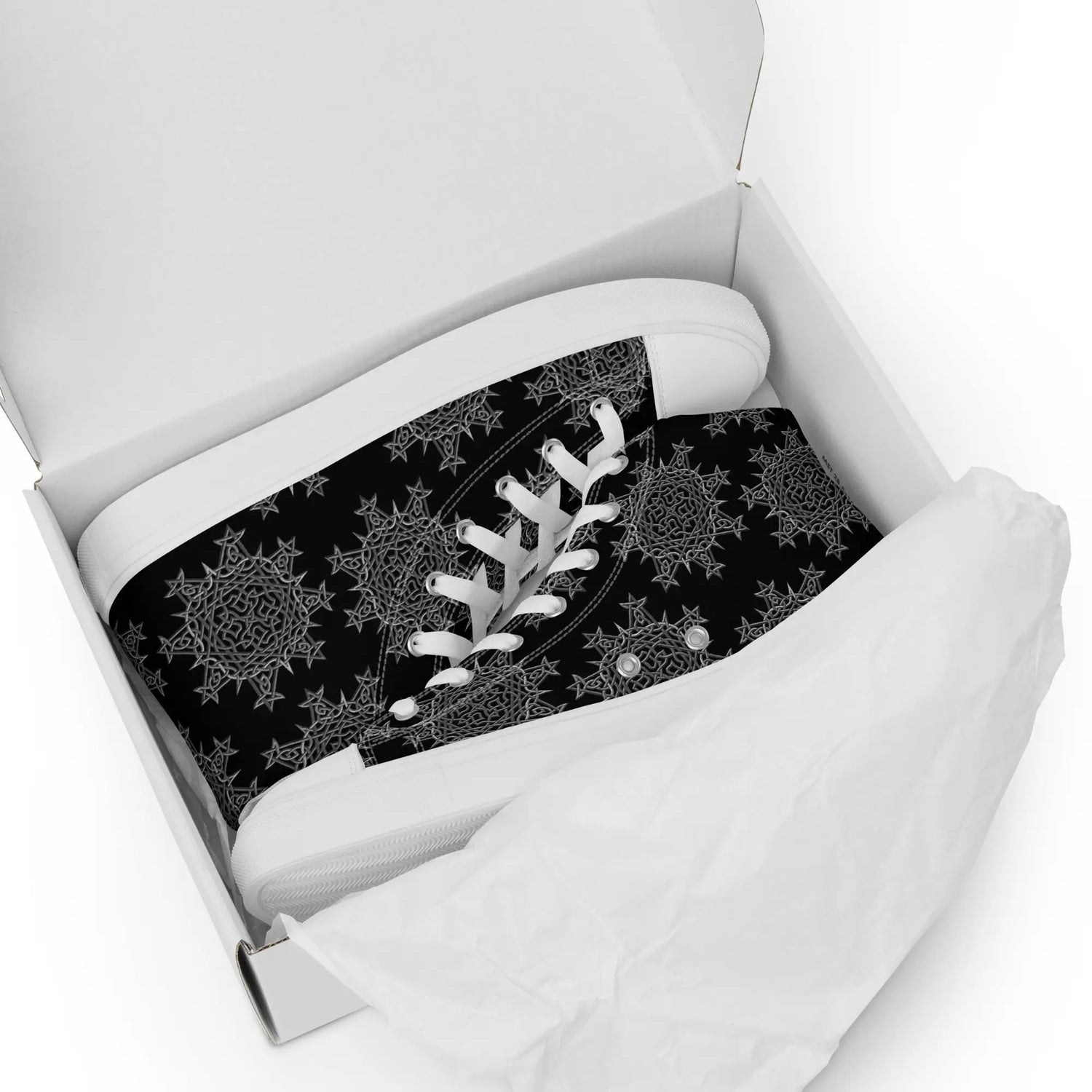A shoebox containing a pair of black Xigfireon canvas high tops featuring the Greyscale iteration of the Morning Star Fire Celtic knot pattern.