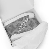 A shoebox containing a pair of Xigfireon canvas high tops featuring the Inverted Black & White Solid iteration of the Reach of The Spirit Celtic knot pattern.