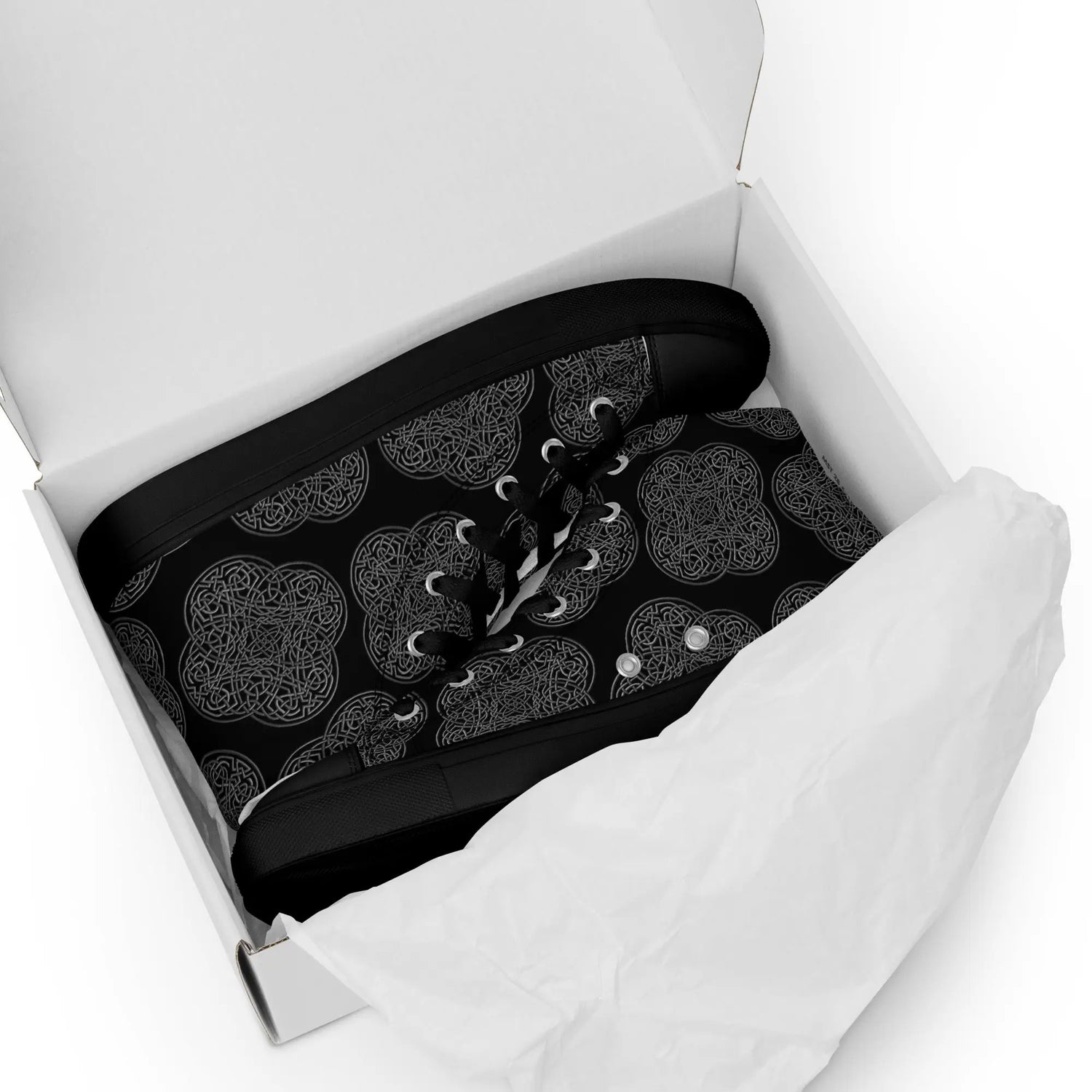 A shoebox containing a pair of Xigfireon black soled canvas high tops featuring the Greyscale iteration of the Reach Of The Spirit Celtic knot pattern.