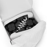 A shoebox containing a pair of Xigfireon black canvas high tops featuring the Greyscale iteration of the Reach Of The Spirit Celtic knot pattern.