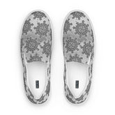 A view from above of a pair of Xigfireon canvas slip-ons featuring the Inverted Black & White Solid Cosmos iteration of the Morning Star Fire Celtic knot pattern. The Xigfireon logo is visible inside each shoe.