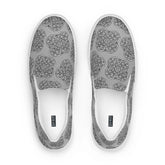 A view from above of a pair of Xigfireon canvas slip-ons featuring the Inverted Black & White Solid iteration of the Reach of The Spirit Celtic knot pattern. The Xigfireon logo is visible inside each shoe.