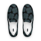 A view from above of a pair of Xigfireon canvas slip-on shoes featuring the Living Colour on Black iteration of the Reach Of The Spirit Celtic knot pattern. The Xigfireon logo is visible inside each shoe.