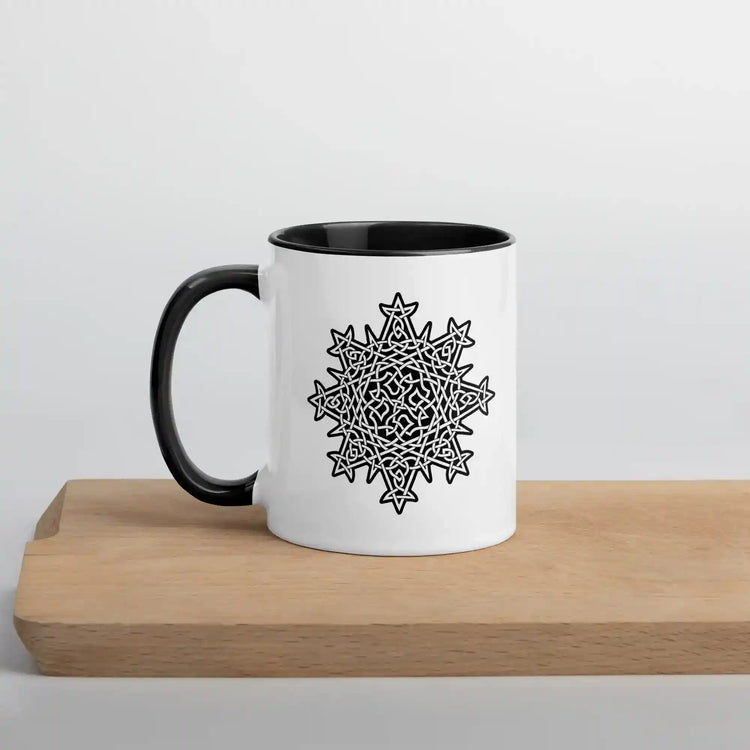 A cutting board displaying a Xigfireon white ceramic 11oz mug featuring the Black & White Solid iteration of the Morning Star Fire Celtic knot design, with black handle and inside. This Celtic knot symbolizes Father Sun.