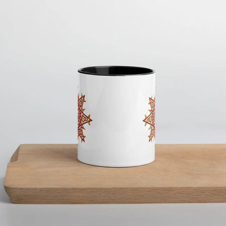 The front side of a Xigfireon white ceramic 11oz mug featuring the Fire Colour iteration of the Morning Star Fire Celtic knot design, with black handle and inside. This Celtic knot symbolizes Father Sun.