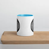 A Xigfireon white ceramic 11oz mug featuring the Black & White Circle iteration of the Reach Of The Spirit Celtic knot design, with blue handle and inside. This Celtic knot symbolizes Mother Earth.