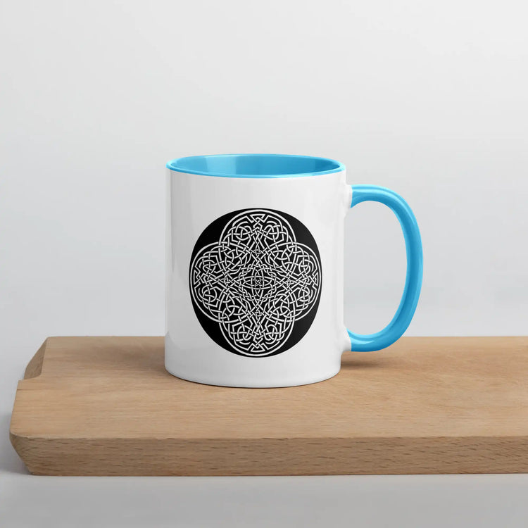 A Xigfireon white ceramic 11oz mug featuring the Black & White Circle iteration of the Reach Of The Spirit Celtic knot design, with blue handle and inside. This Celtic knot symbolizes Mother Earth.