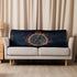 A sofa covered by a 37 inch by 57 inch Xigfireon sublimated sherpa blanket featuring the Eclipsed iteration of the Morning Star Fire Celtic knot design. Inspired by the 2023 Annular Solar Eclipse.