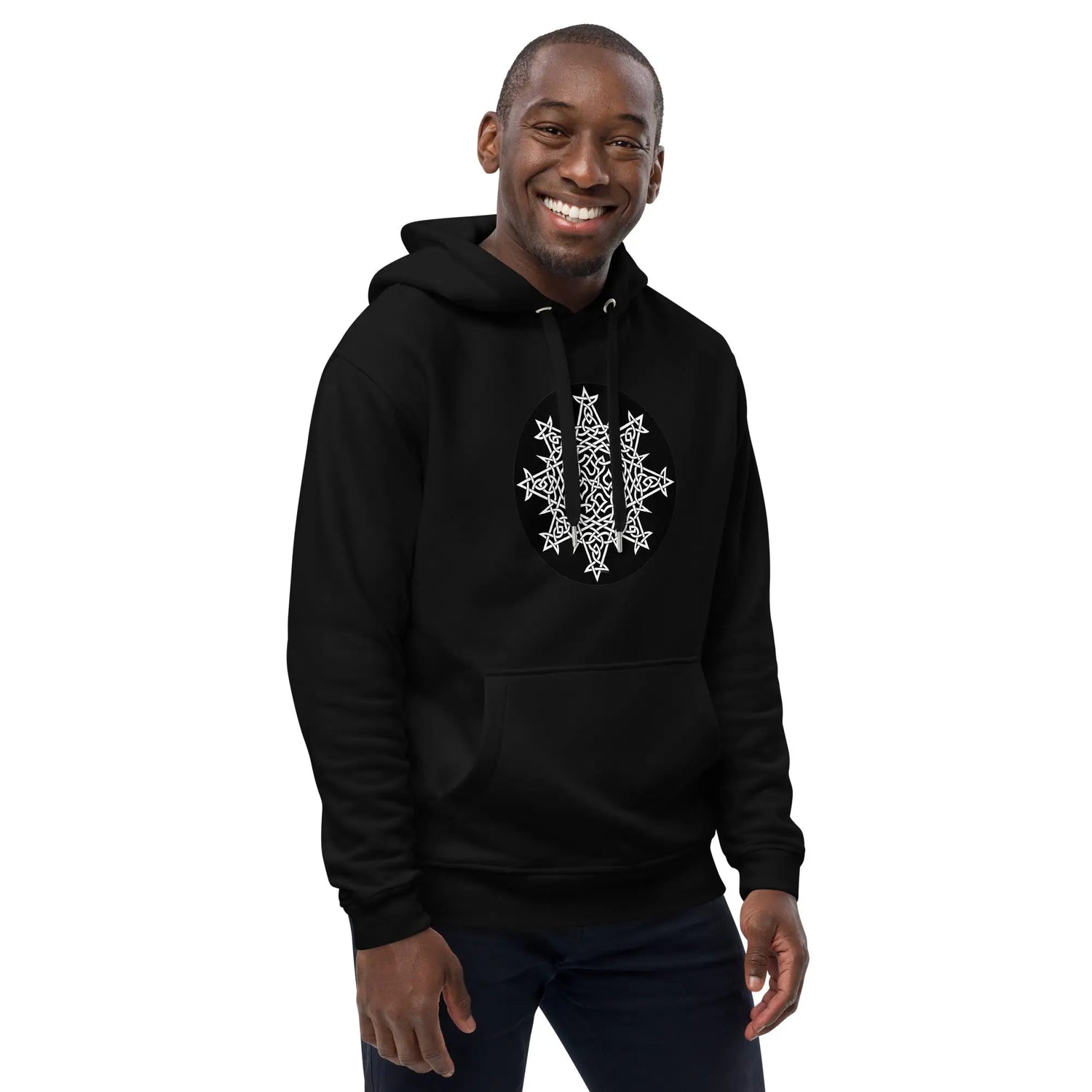 A young man wearing a black Xigfireon graphic eco hoodie featuring the Black & White Circle iteration of the Morning Star Fire Celtic knot design. The Morning Star Fire Celtic knot symbolizes the Sun.