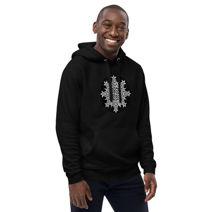 A young man wearing a black Xigfireon graphic eco hoodie featuring the Black &amp; White Circle iteration of the Morning Star Fire Celtic knot design. The Morning Star Fire Celtic knot symbolizes the Sun.