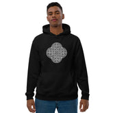 A young man wearing a black Xigfireon graphic eco hoodie featuring the Black & White Hollow iteration of the Reach Of The Spirit Celtic knot design. The Reach Of The Spirit Celtic knot is an Earth symbol.