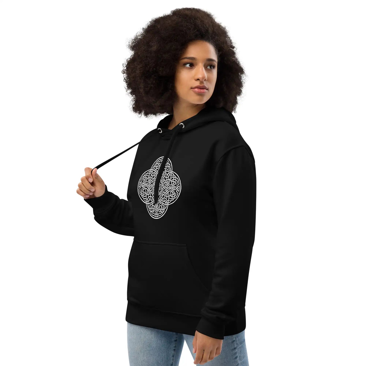 A young woman wearing a black Xigfireon graphic eco hoodie featuring the Black & White Solid iteration of the Reach Of The Spirit Celtic knot design. The Reach Of The Spirit Celtic knot symbolizes our magnificent Mother Earth.