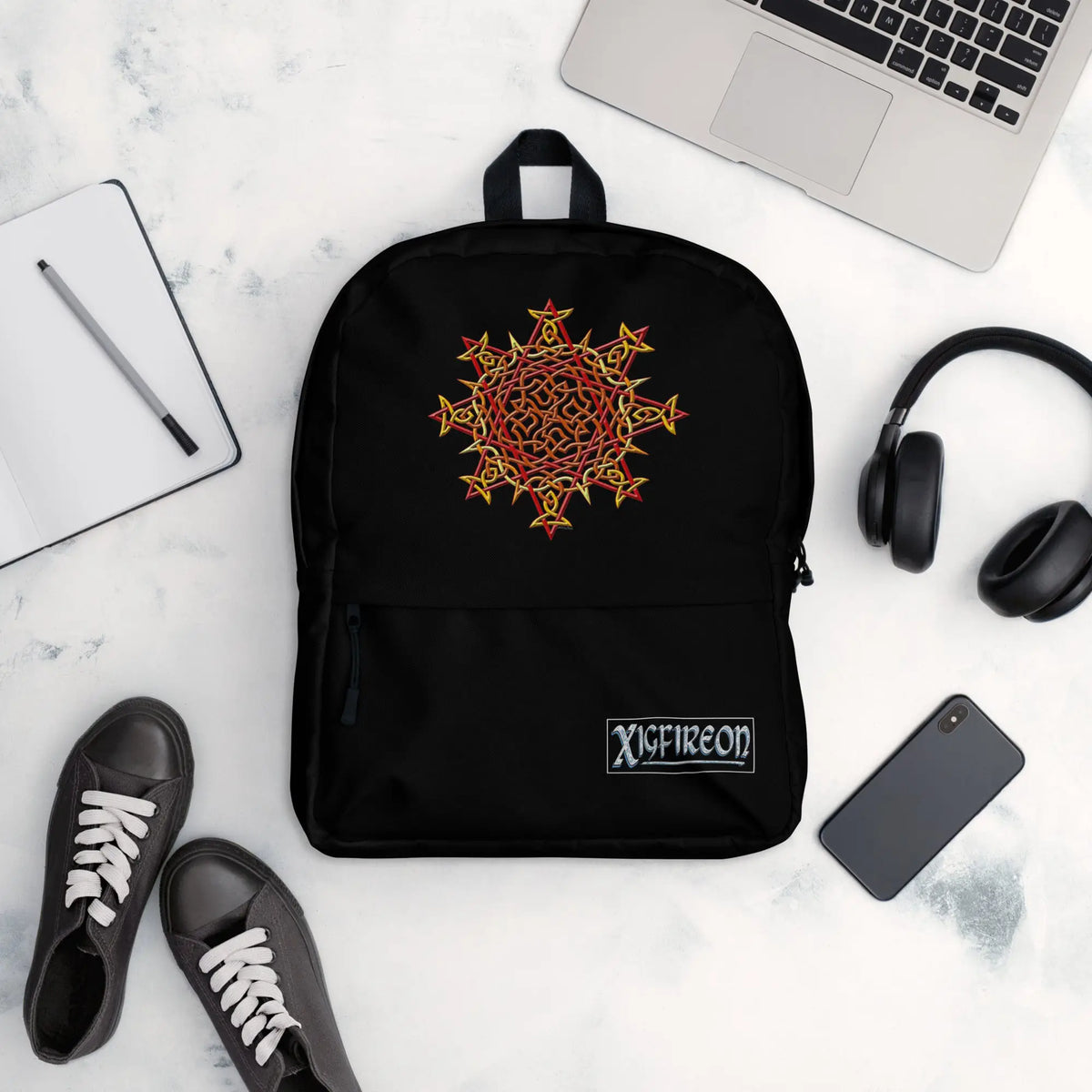 A view of a few new school year essentials, including a Xigfireon graphic backpack featuring the Fire Colour iteration of the Morning Star Fire Celtic knot design.