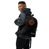A student wearing a Xigfireon graphic backpack featuring the Fire Colour iteration of the `Morning Star Fire` Celtic knot design. The `Morning Star Fire` Celtic knot symbolizes Father Sun.
