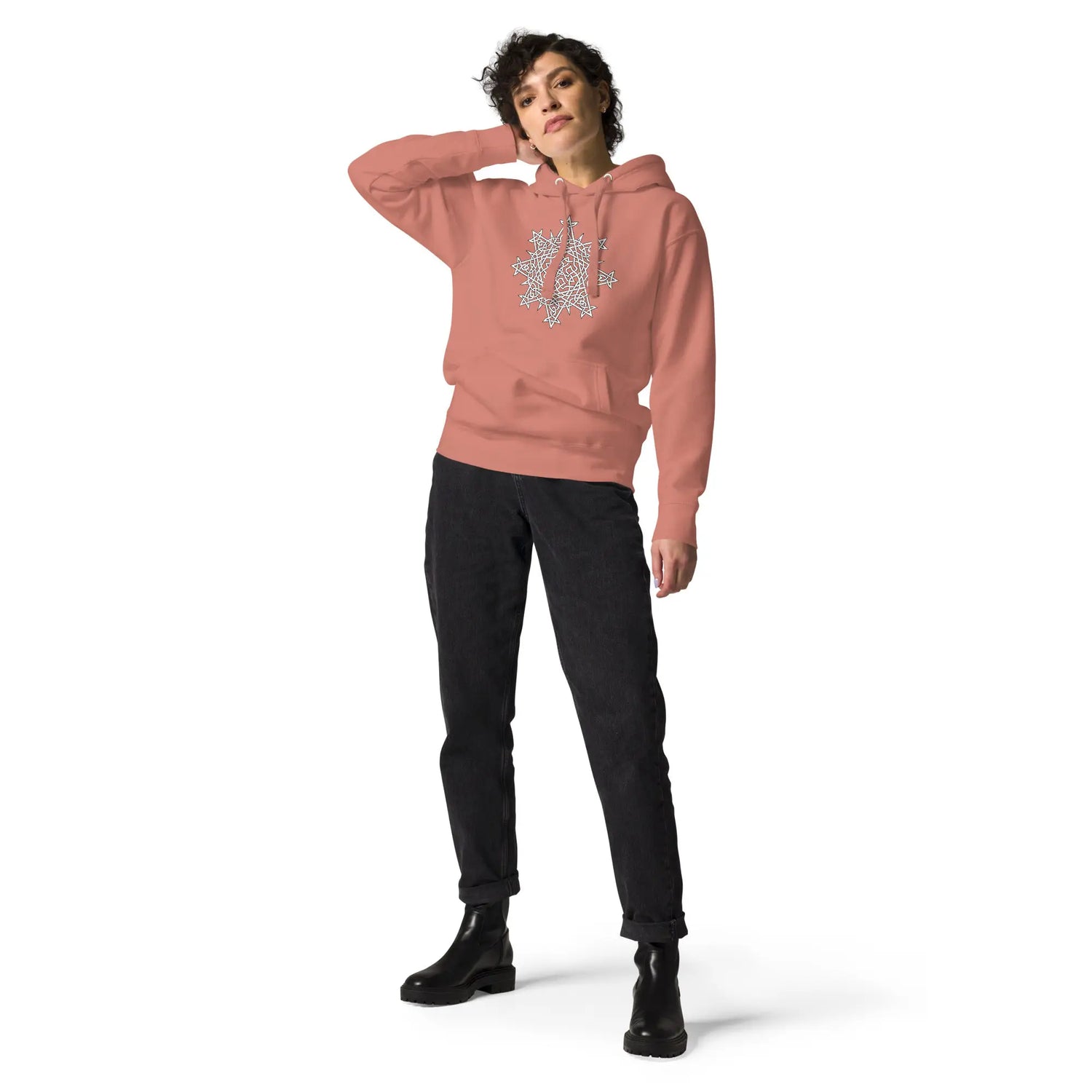 A young woman wearing a dusty rose Xigfireon graphic hoodie featuring the Black & White Hollow iteration of the Morning Star Fire Celtic knot design. This Celtic knot symbolizes the Sun.