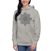 A young woman wearing a carbon grey Xigfireon graphic hoodie featuring the Black & White Solid iteration of the Morning Star Fire Celtic knot design. This Celtic knot symbolizes the Sun.