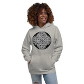 A young woman wearing a carbon grey Xigfireon graphic hoodie featuring the Black & White Circle iteration of the Reach Of The Spirit Celtic knot design. The Reach Of The SpiritC eltic knot represents the Earth.