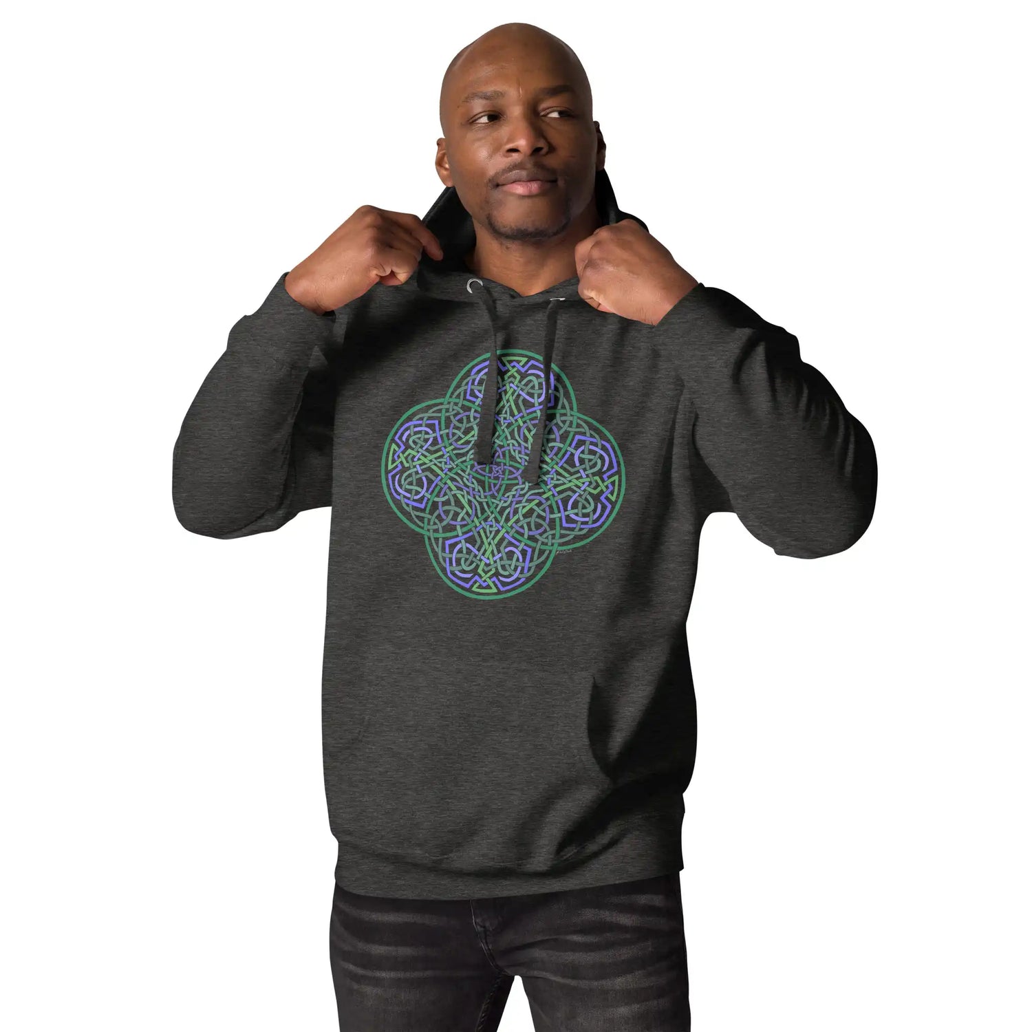 A young man wearing a charcoal heather Xigfireon graphic hoodie featuring the Living Colour Flat iteration of the Reach Of The Spirit Celtic knot design. The Reach Of The Spirit Celtic knot symbolizes the Earth.