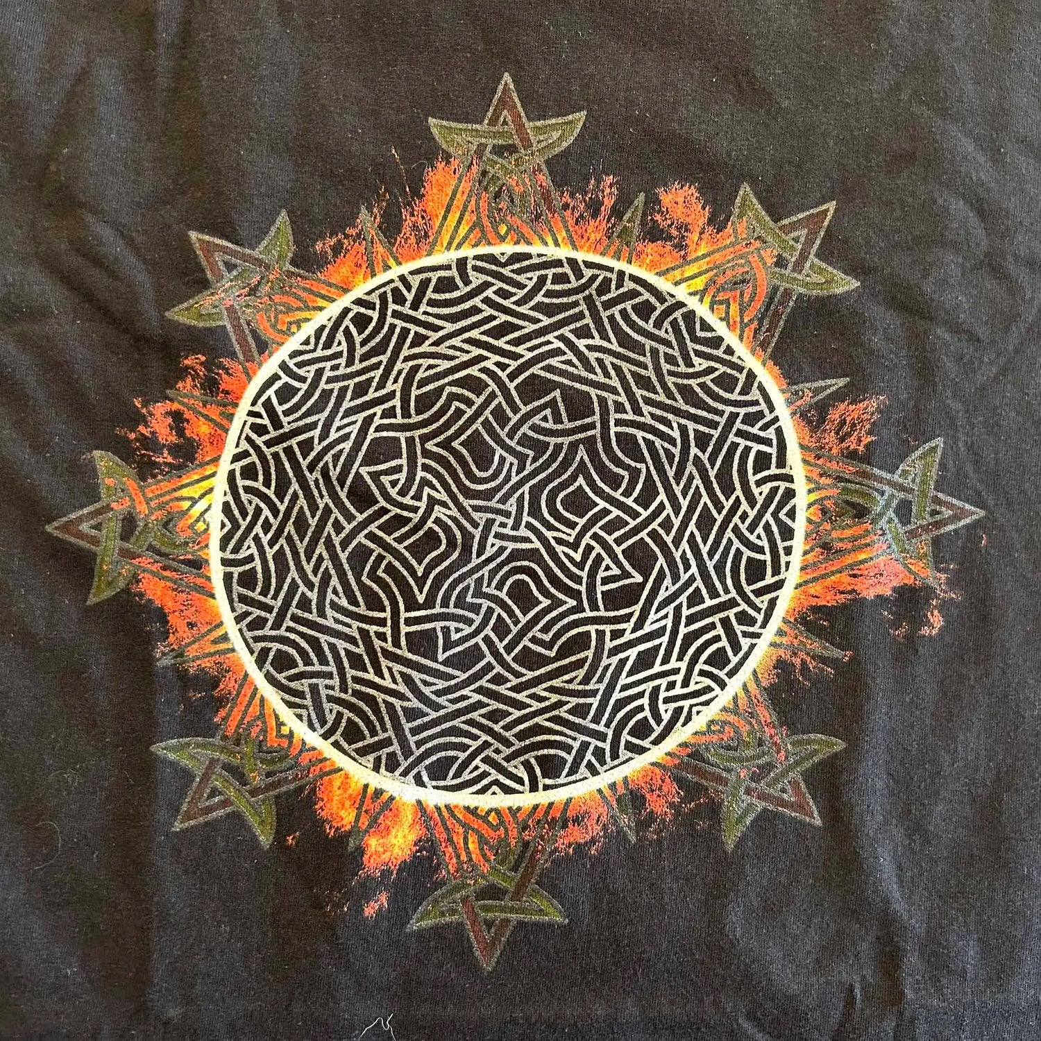 A close-up view of a classic black Xigfireon graphic tee featuring the Eclipsed iteration of the Morning Star Fire Celtic knot design, inspired by the Annular Solar Eclipse of 2023.