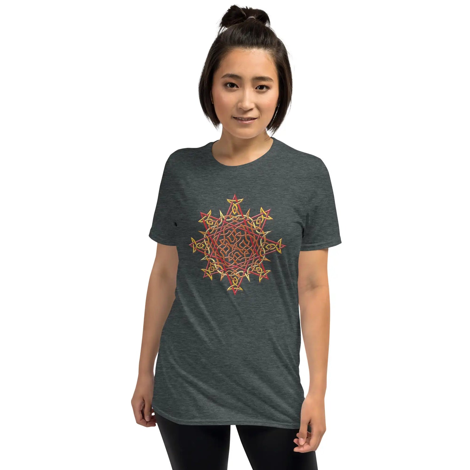 A young woman wearing a dark heather Xigfireon graphic t-shirt featuring the Fire Colour iteration of the Morning Star Fire Celtic knot design. The Morning Star Fire Celtic knot symbolizes Father Sun.