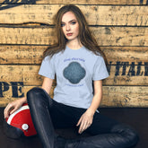 A young woman wearing a baby blue Xigfireon graphic t-shirt featuring the Blue Slate iteration of the `Reach Of The Spirit` Celtic knot design along with a message in a Celtic font: "Our Mother, Cherish Her".