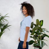 A young woman wearing a baby blue Xigfireon graphic t-shirt featuring the Living Colour iteration of the `Reach Of The Spirit` Celtic knot design along with a message in a Celtic font: "Our Mother, Cherish Her".