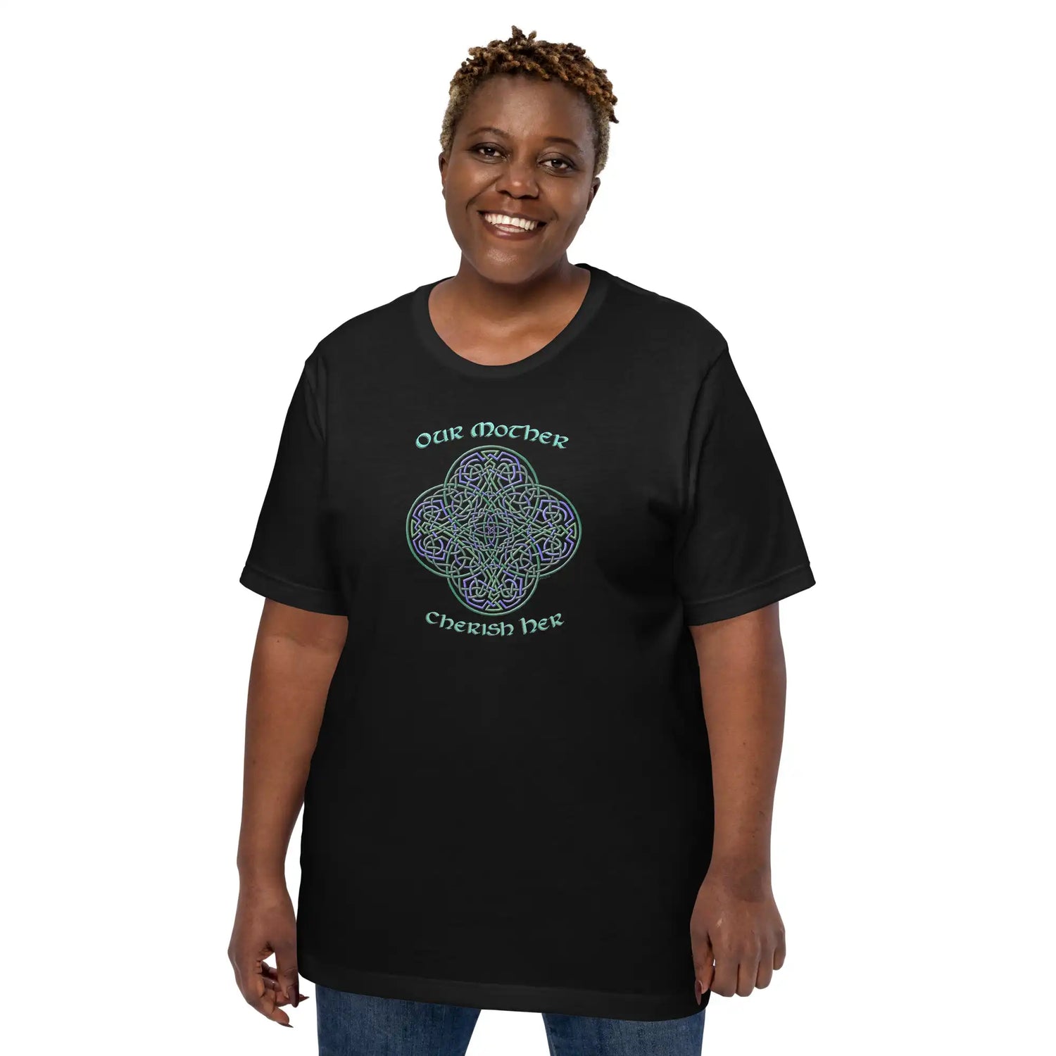 A young woman wearing a black Xigfireon graphic t-shirt featuring the Living Colour iteration of the Reach Of The Spirit Celtic knot design along with a message in a Celtic font: "Our Mother, Cherish Her".