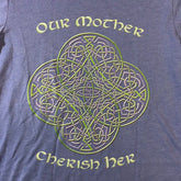 A close up view of a true royal blue Xigfireon graphic t-shirt featuring the Living Colour iteration of the Reach Of The Spirit Celtic knot design along with a message in a Celtic font: "Our Mother, Cherish Her".