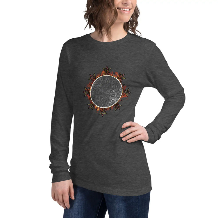 A young woman wearing a dark grey heather Xigfireon long sleeve graphic tee featuring the Eclipsed iteration of the Morning Star Fire Celtic knot design, inspired by the 2023 Annular Solar Eclipse.